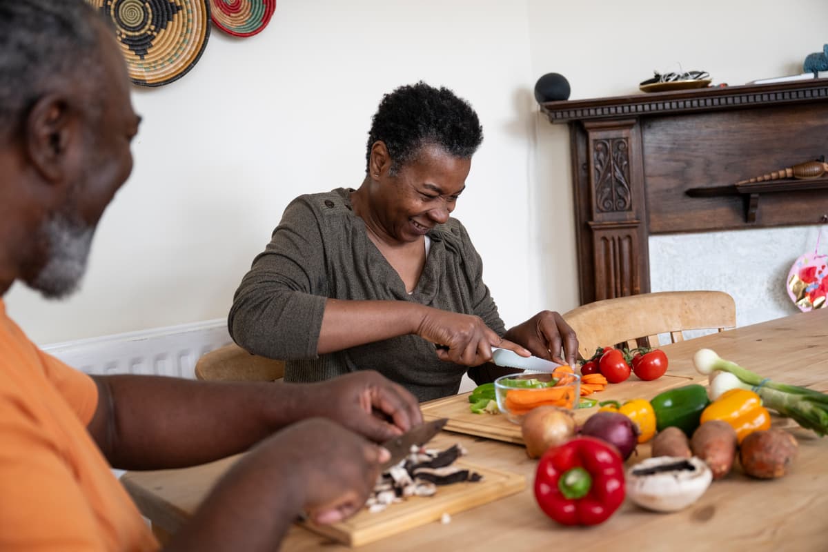 Woman cutting vegetables smiling.