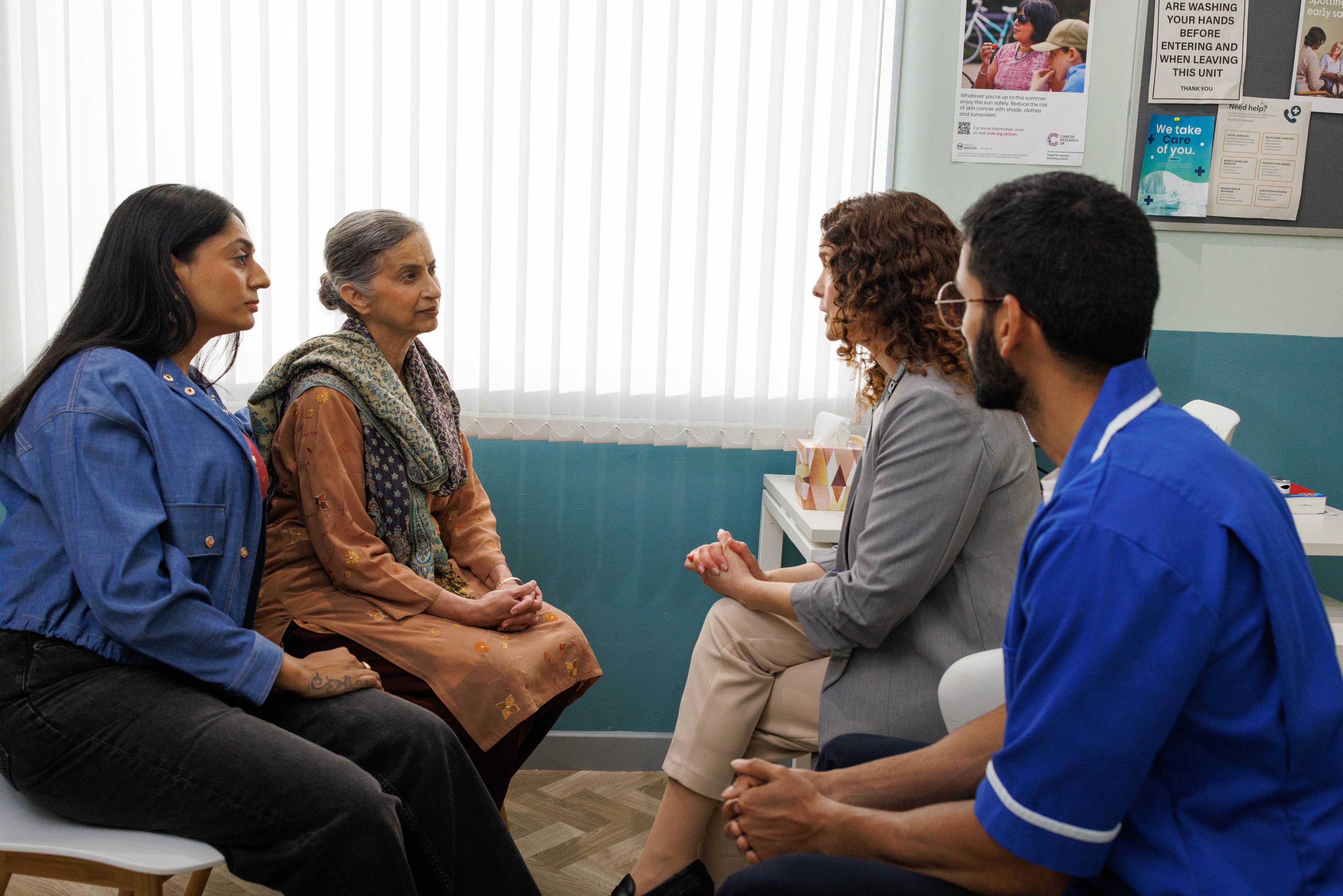 Doctors speaking to the patient and her carer.