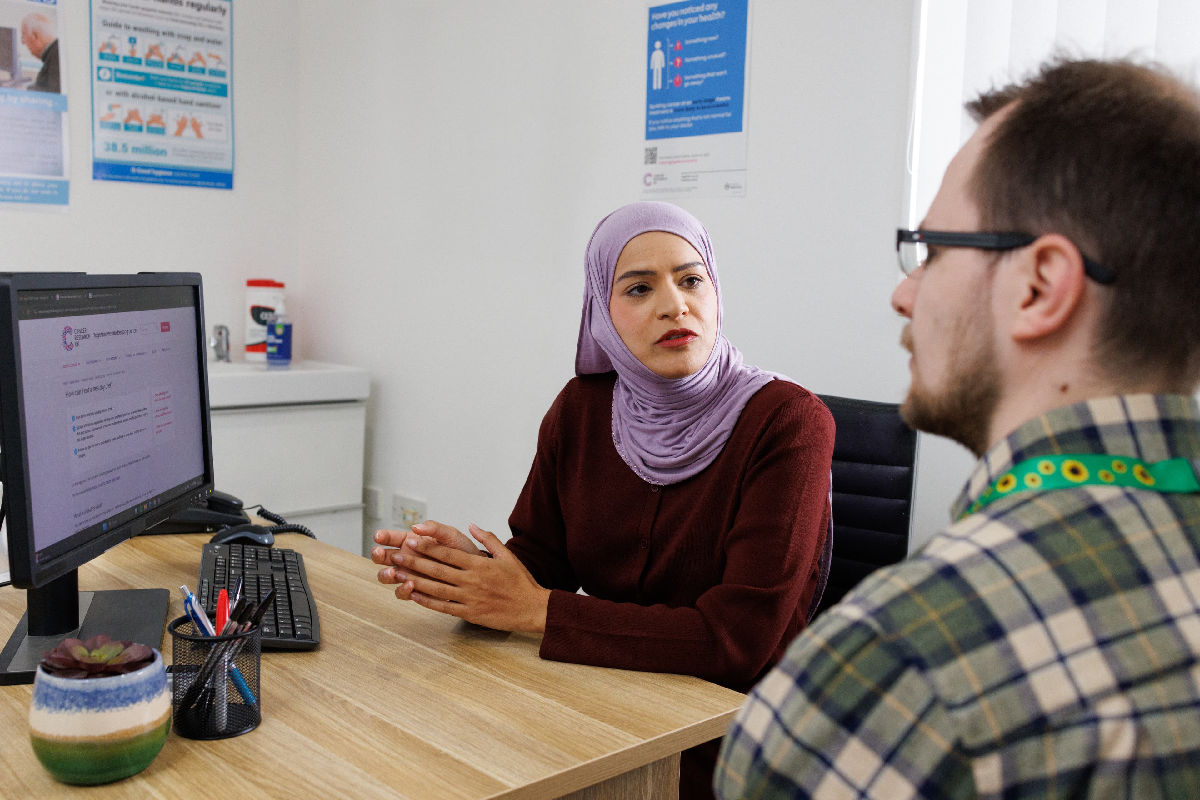Doctor showing the CRUK website to a patient.