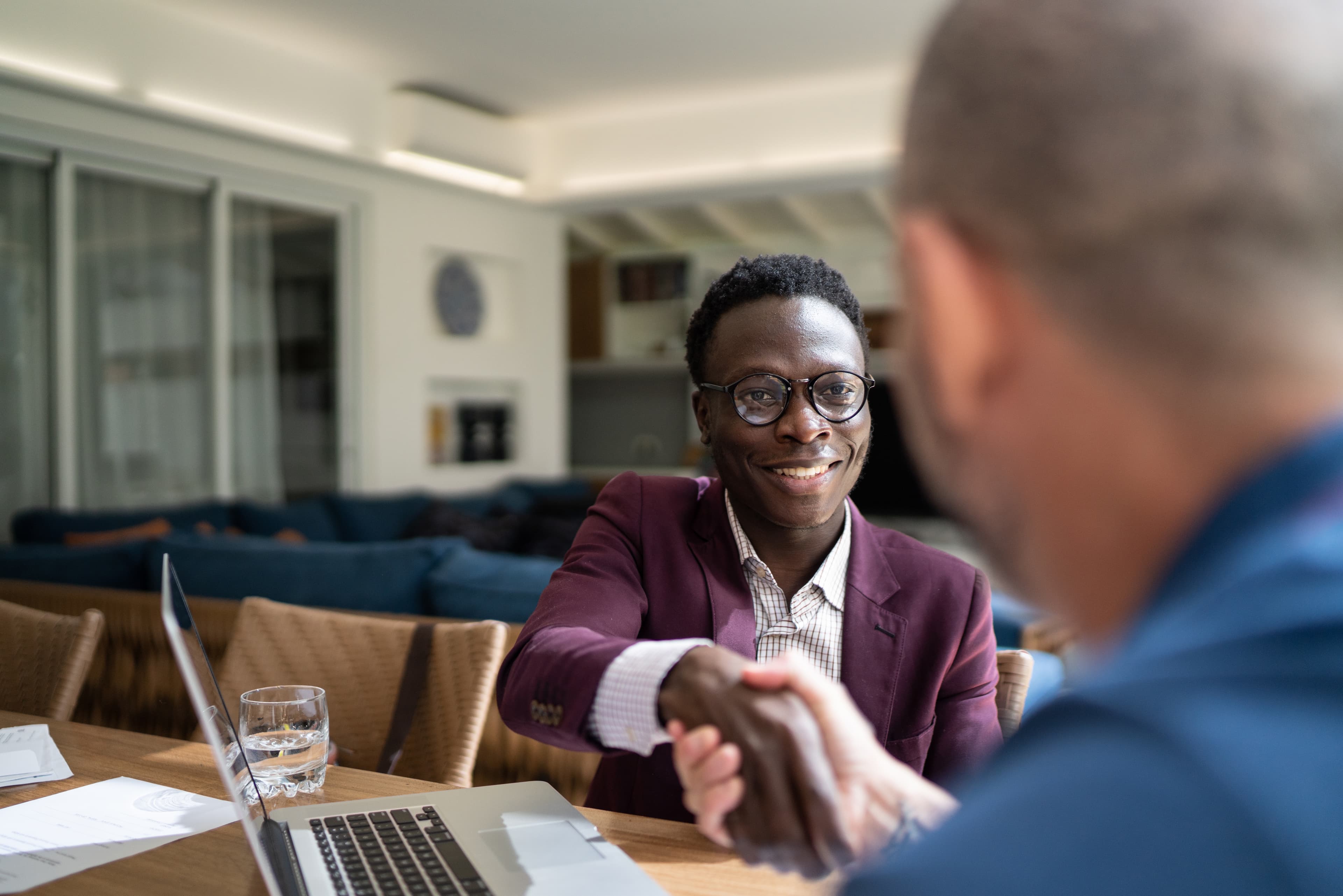 Two men are shaking hands and smiling.
