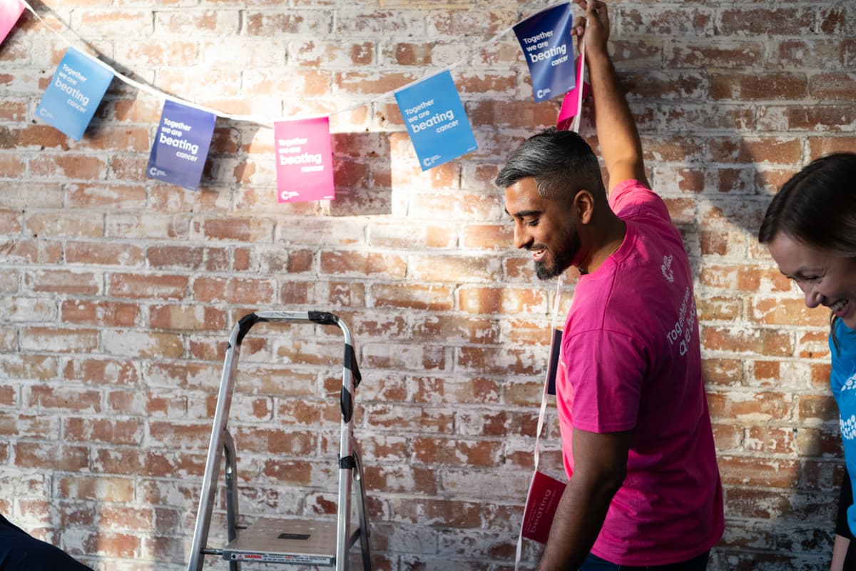 A photo of a Cancer Research UK fundraiser prepping for a bake sale.