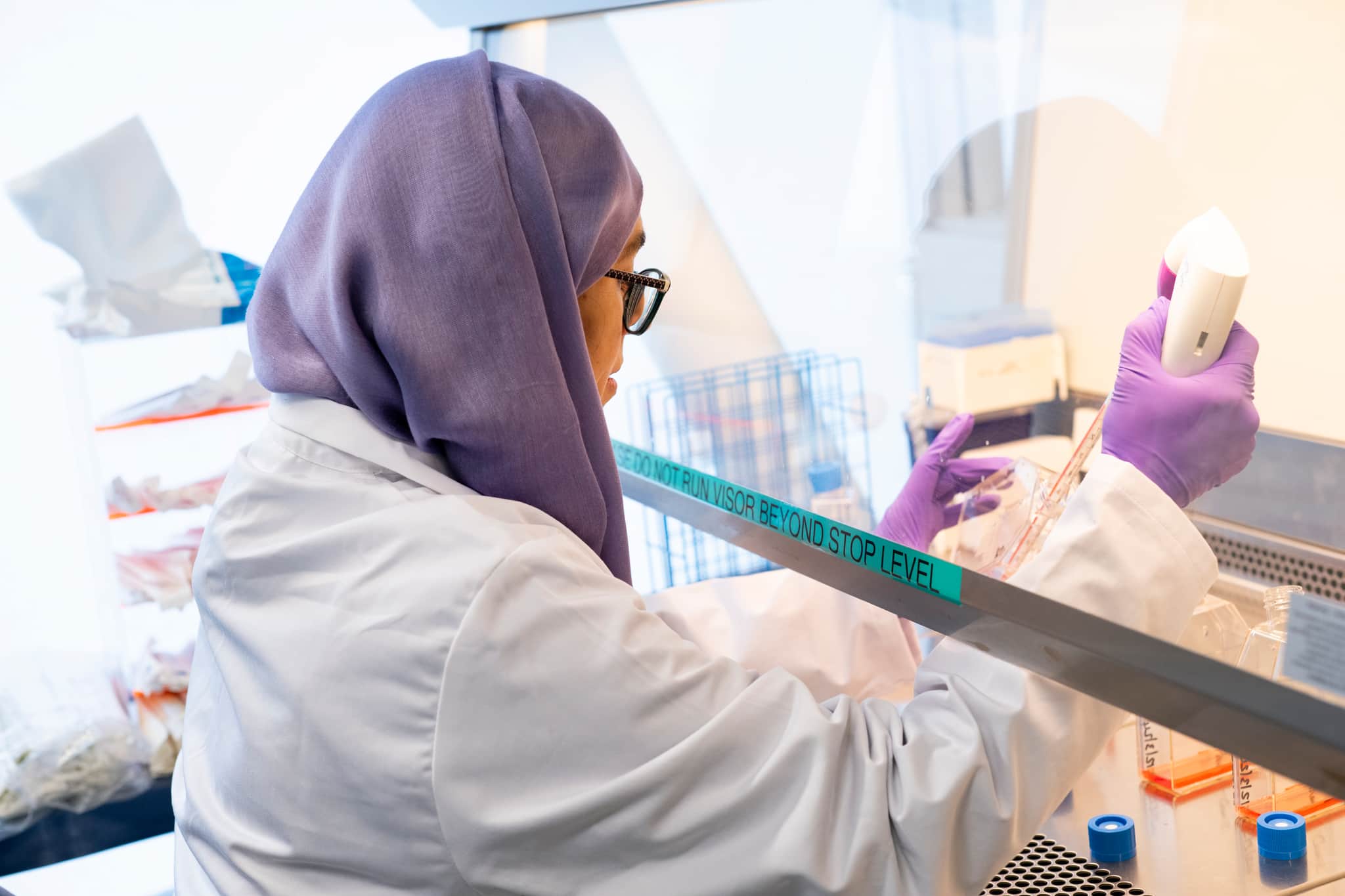 Researcher pipetting in a fume hood.