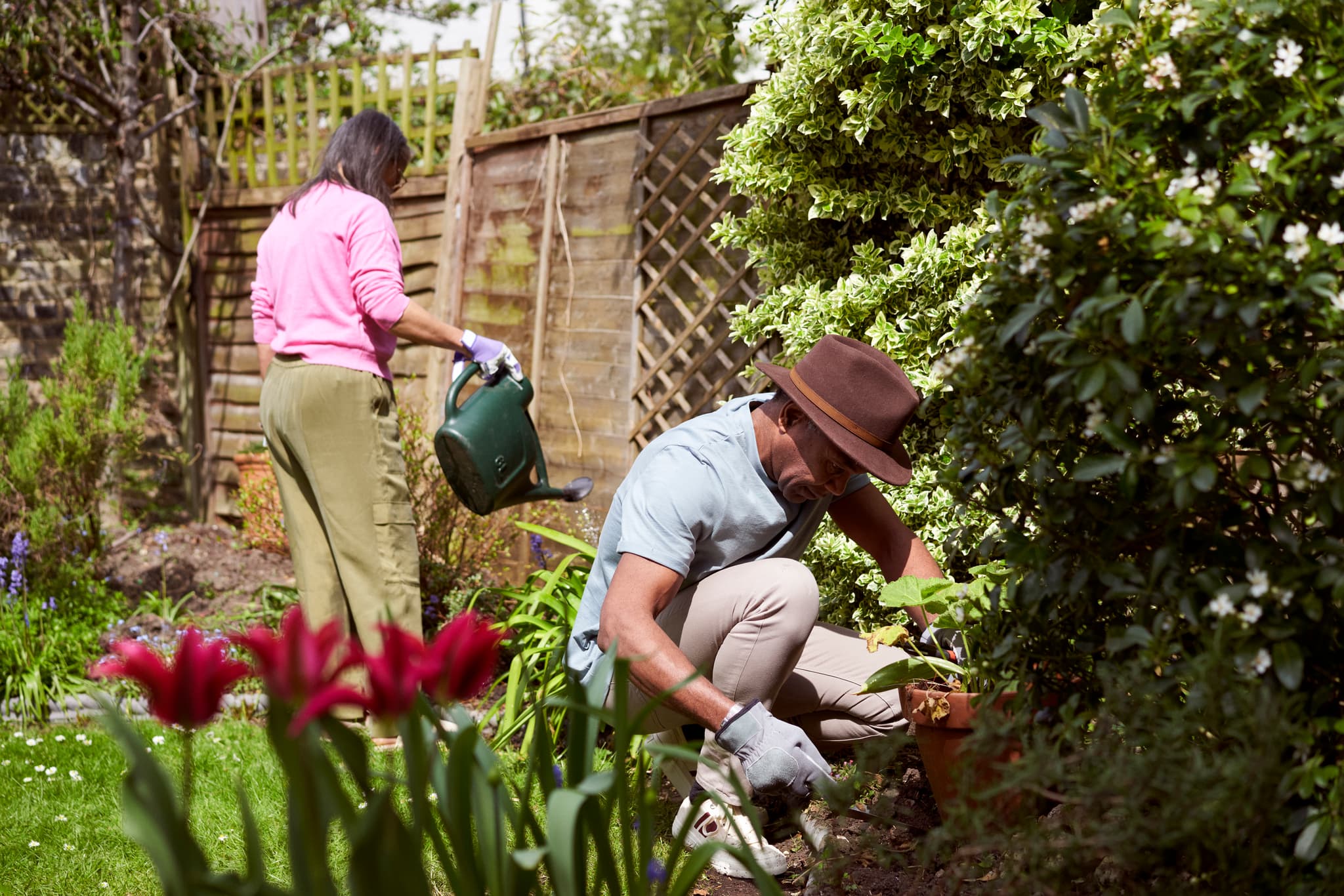 Photograph showing a man and a woman working in a garden.