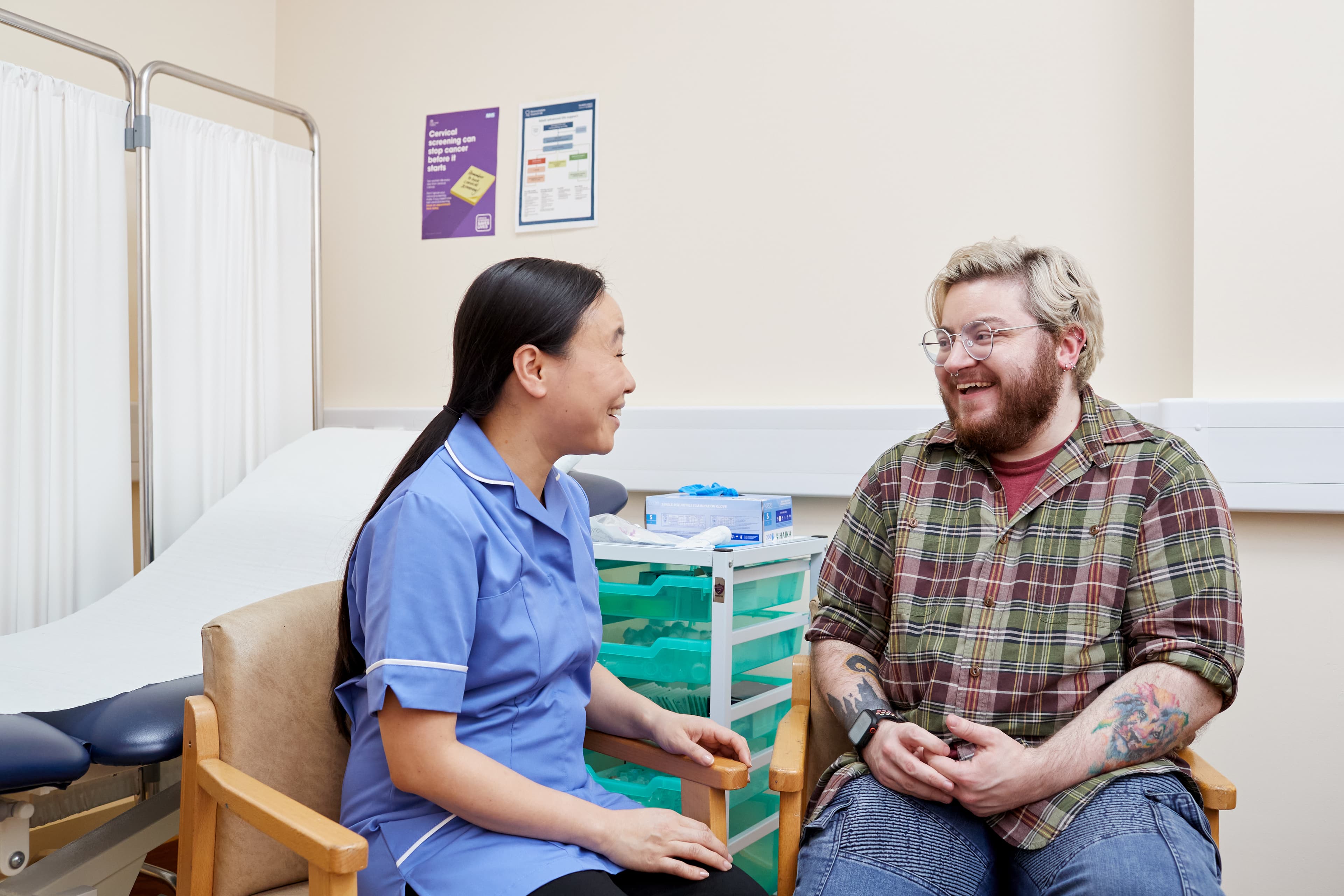 This photo shows a nurse speaking to a transgender male patient about cervical screening.
