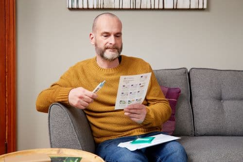 Photo showing a man using a Faecal Immunochemical Test (FIT) kit from Wales.