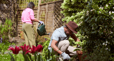 Photograph showing a man and a woman gardening.