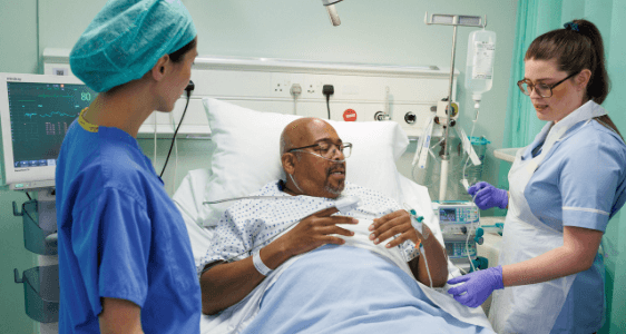 Photo of a man with anaesthetist and nurse after surgery.