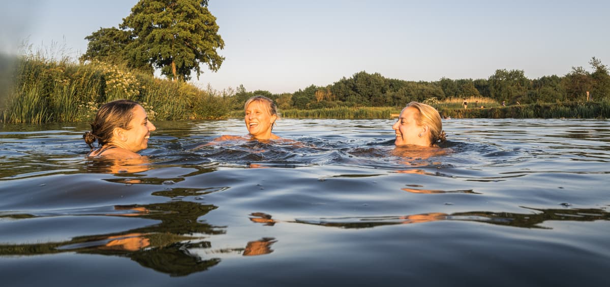 Picture of three women smiling outside in the water.
