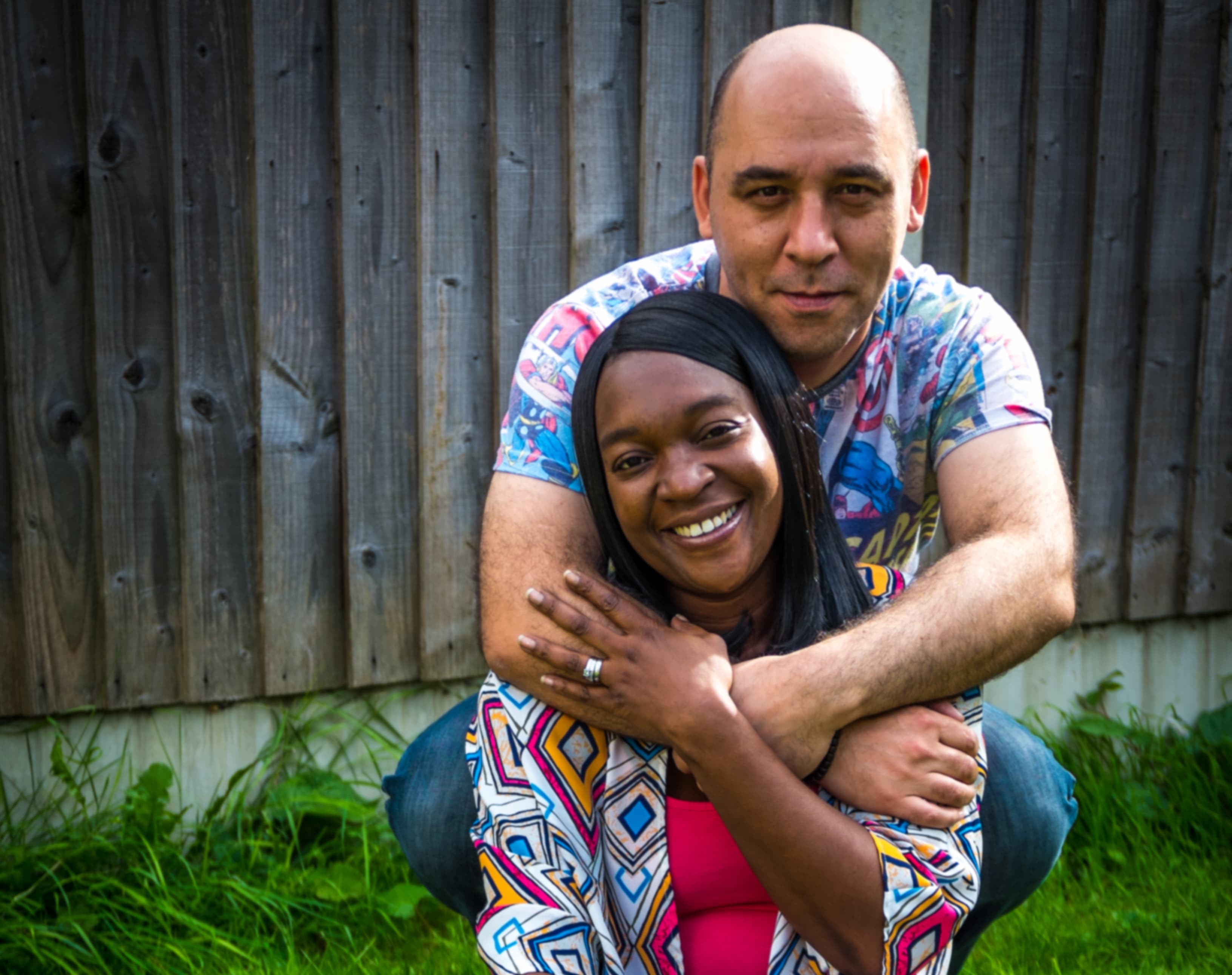 A picture of Amanda smiling and being embraced.