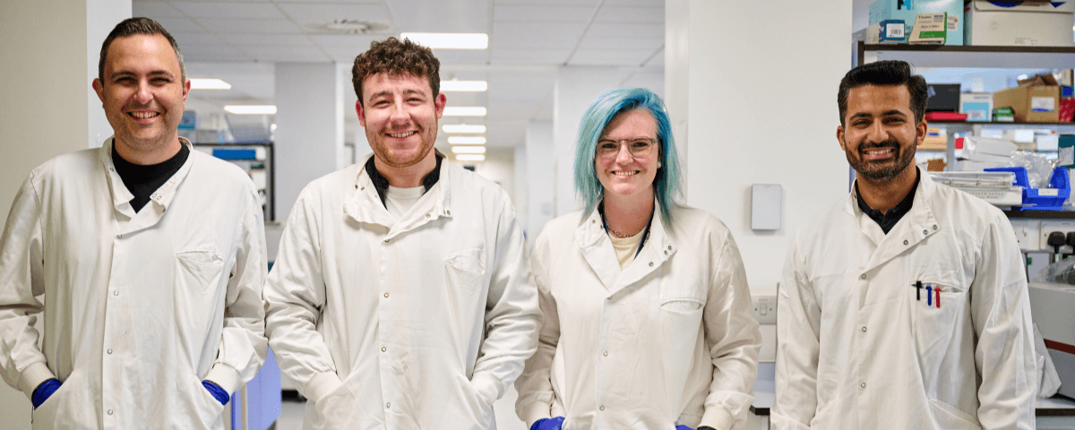 Four researchers smiling to camera.