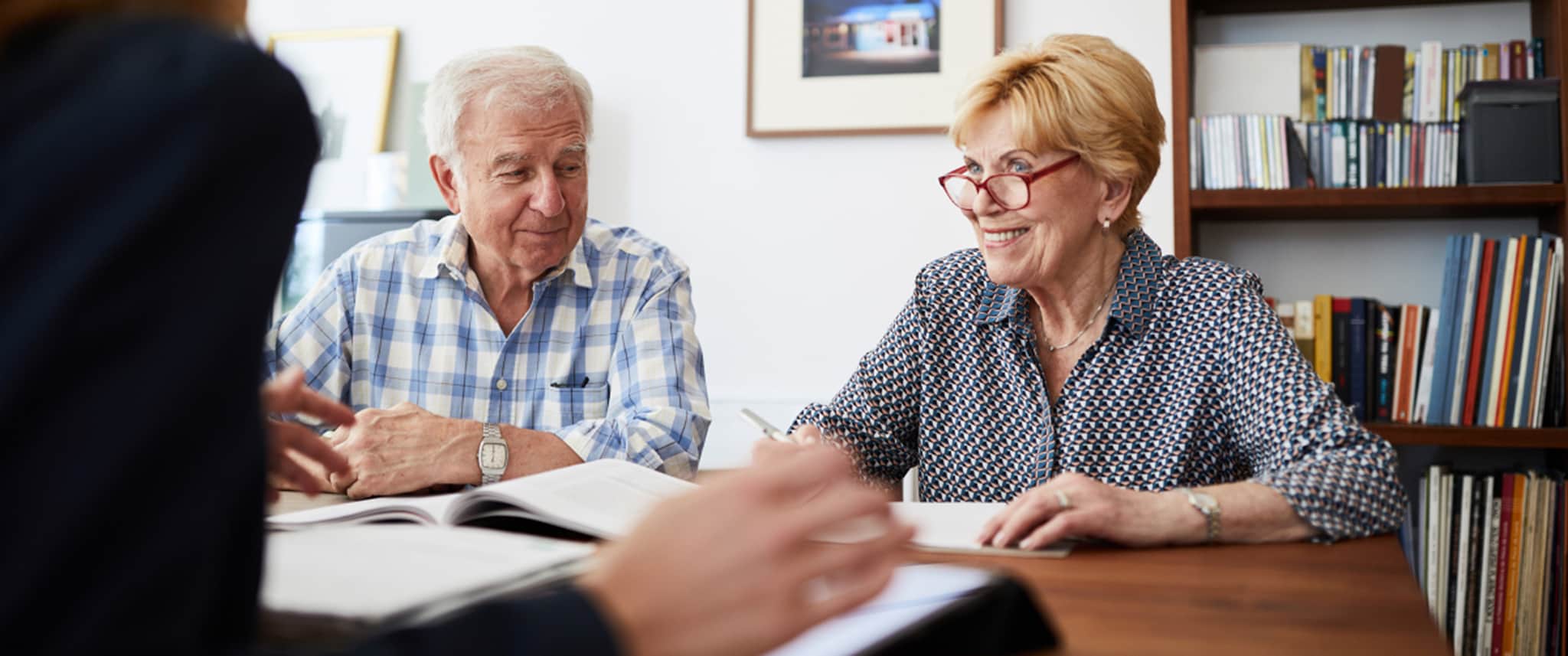Man and a woman sat at a table, talking to a solicitor.
