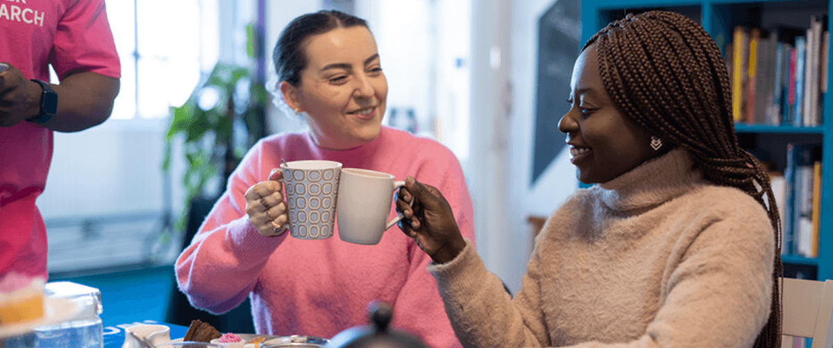 A photo of two Cancer Research UK volunteers having coffee.