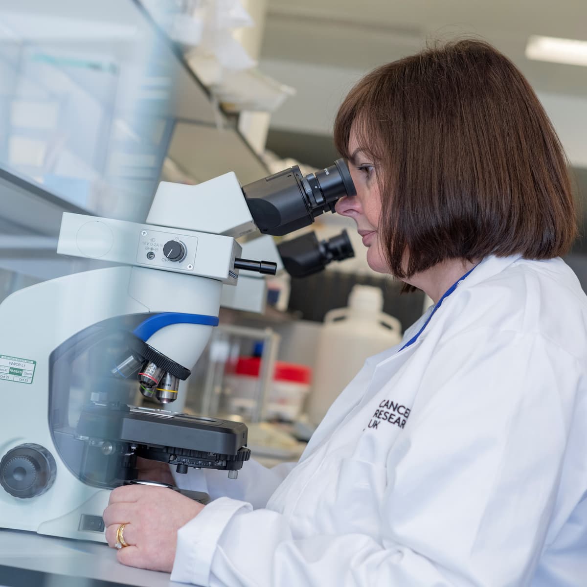 A researcher looking through a microscope.