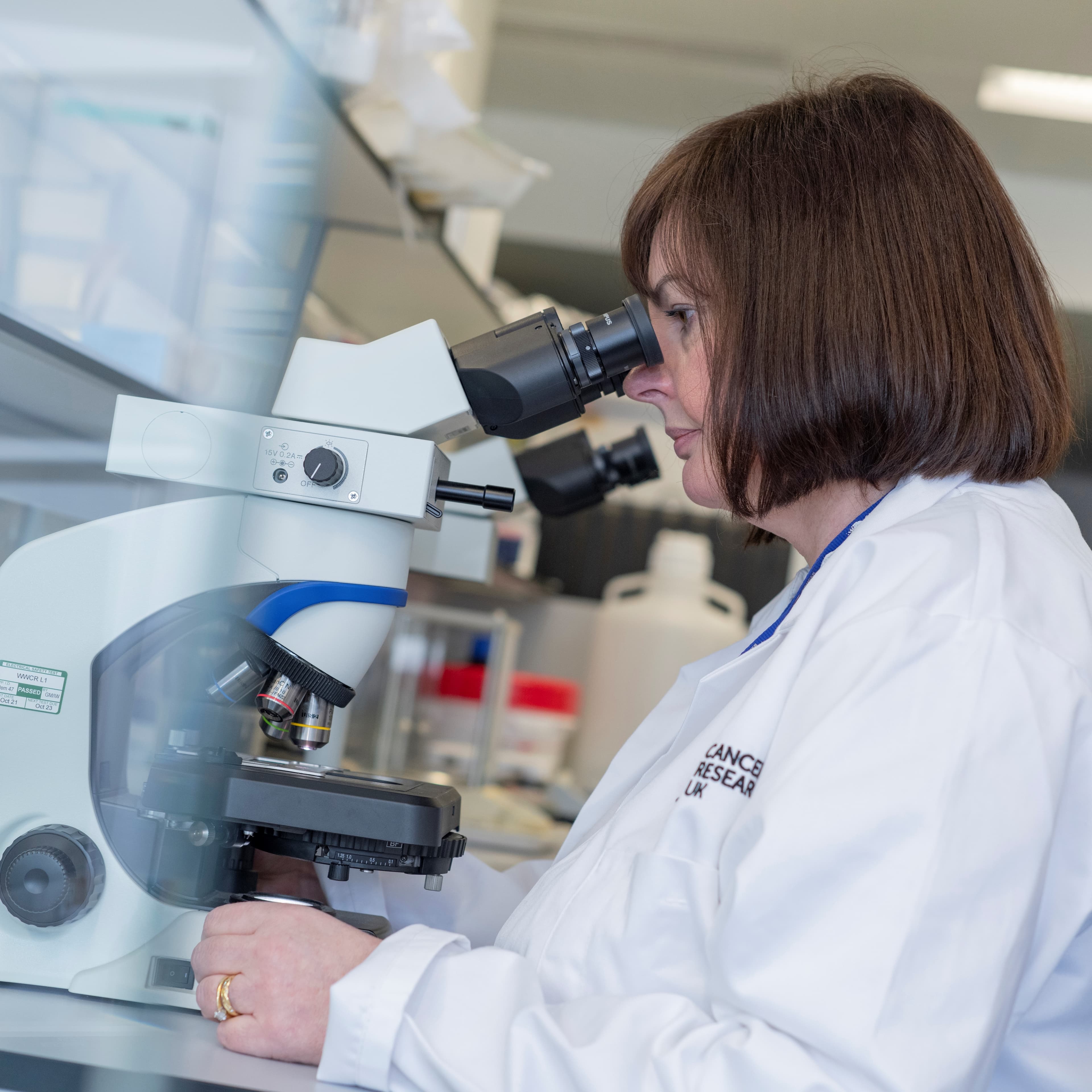 A researcher looking through a microscope.