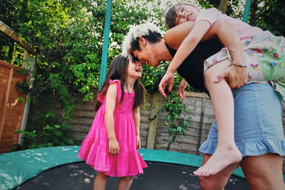 Woman and two kids smiling.