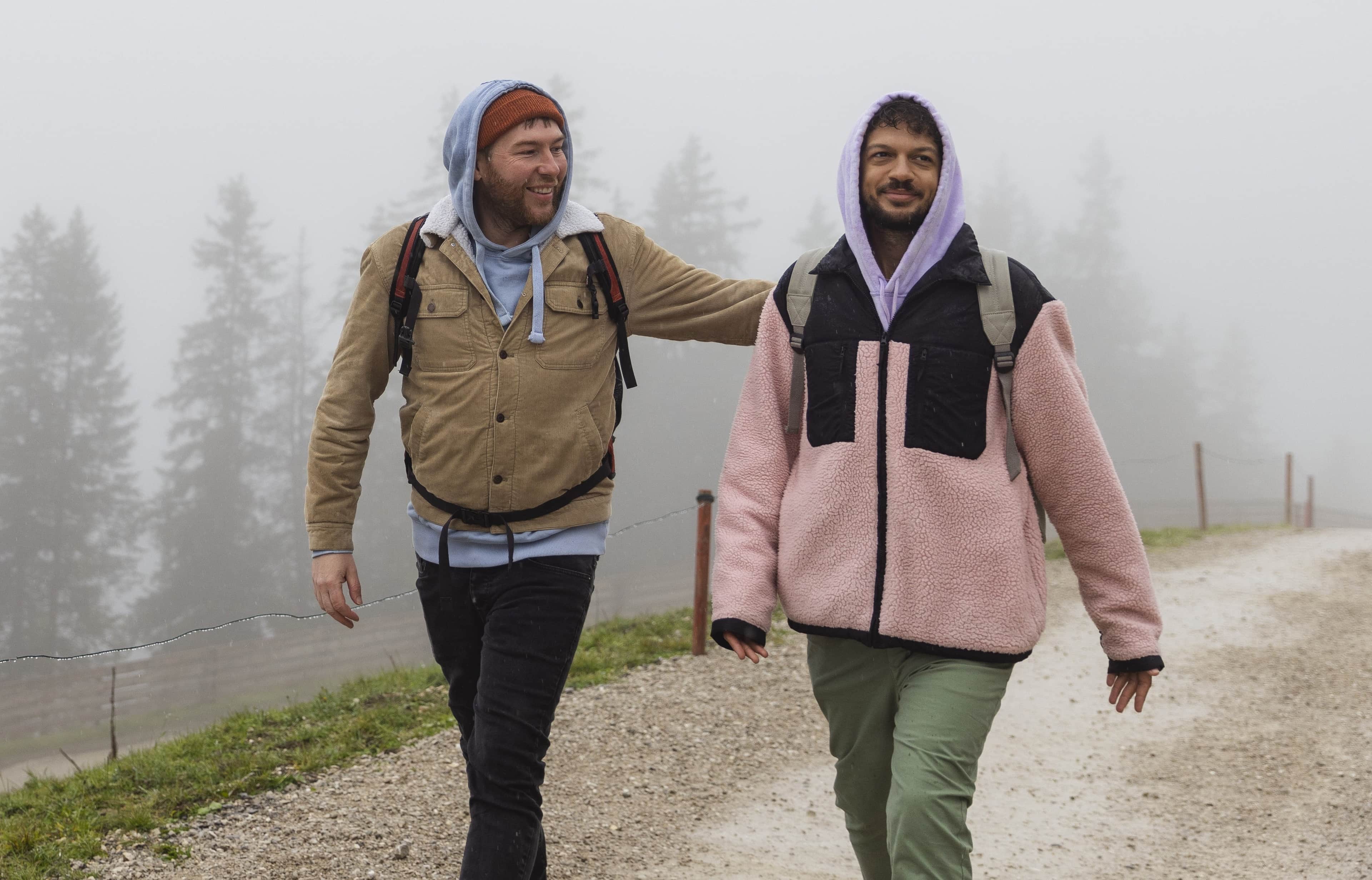 Picture of two men walking on a path with a foggy background.