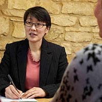 A legal professional taking notes during a meeting.