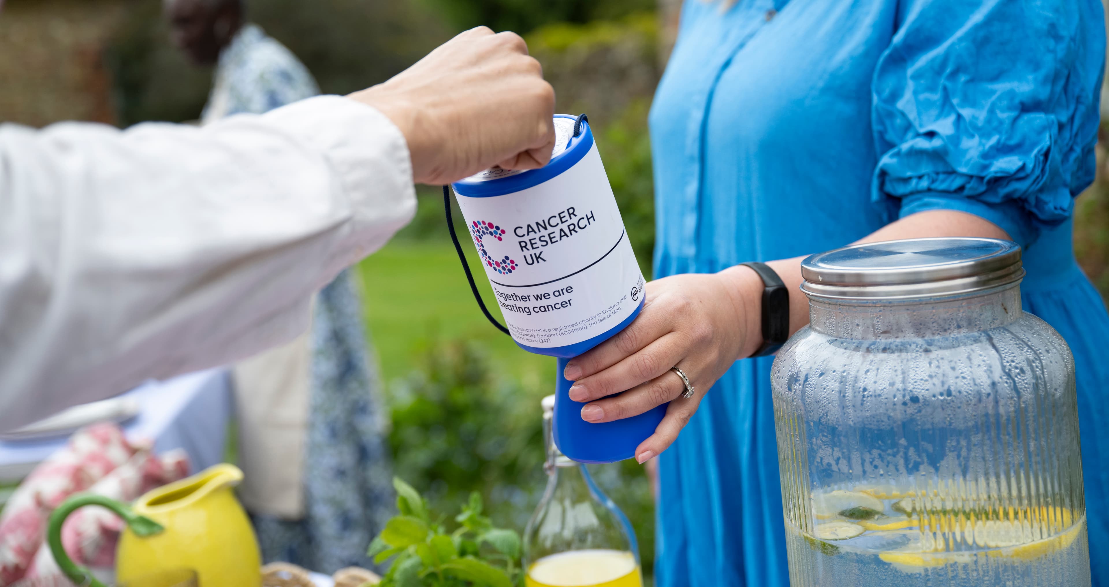 Close-up shot of a person holding a CRUK collection goblet.