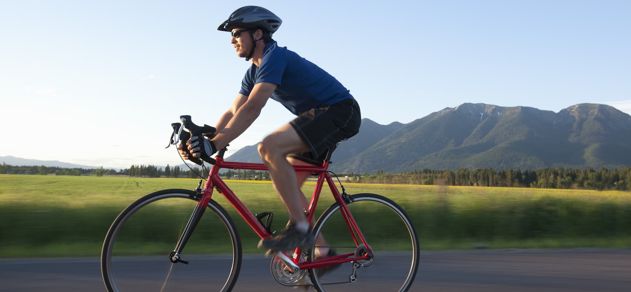 A person cycling outdoors on an empty road.