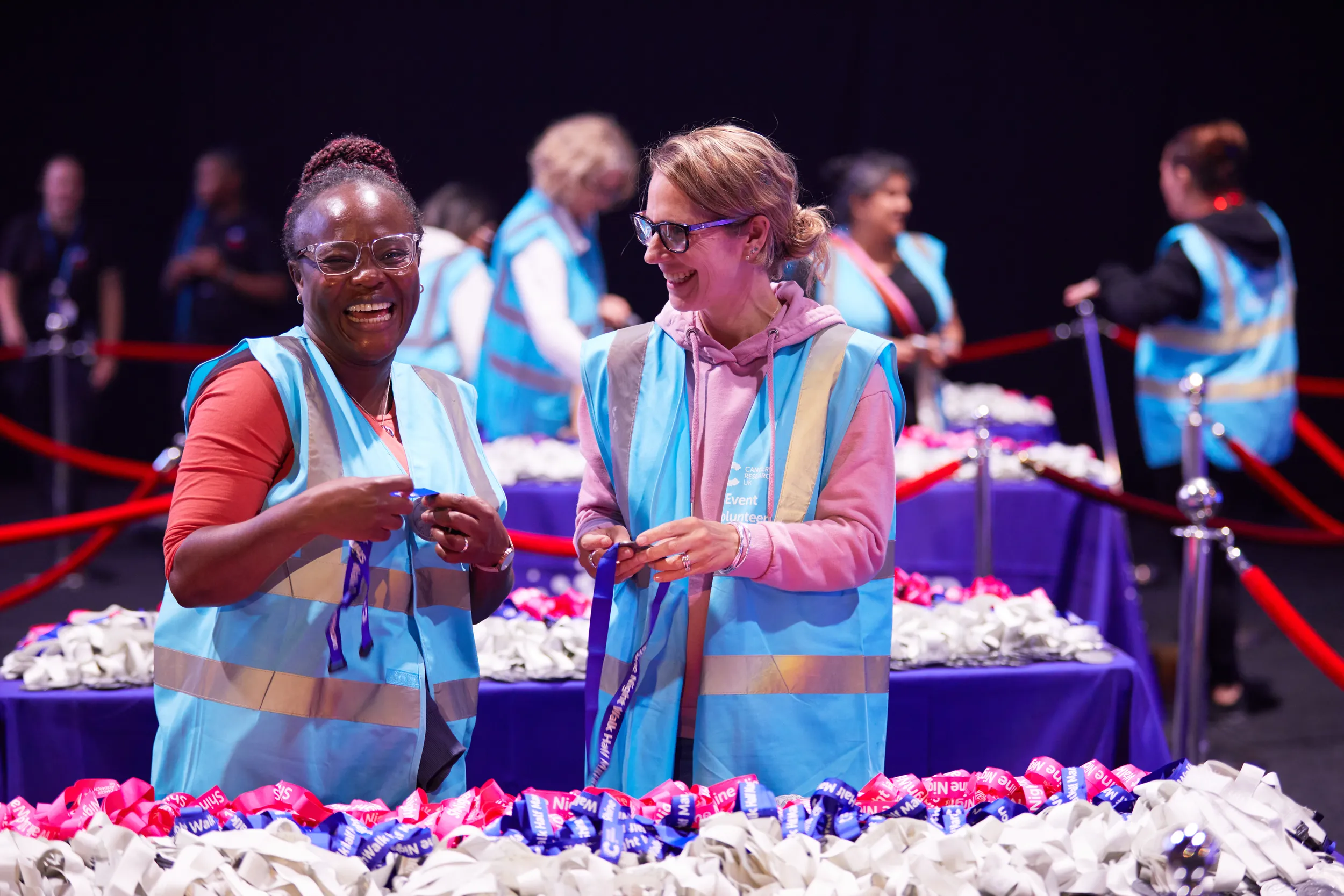 Image of two female volunteers sorting medals at Shine Night Walk.