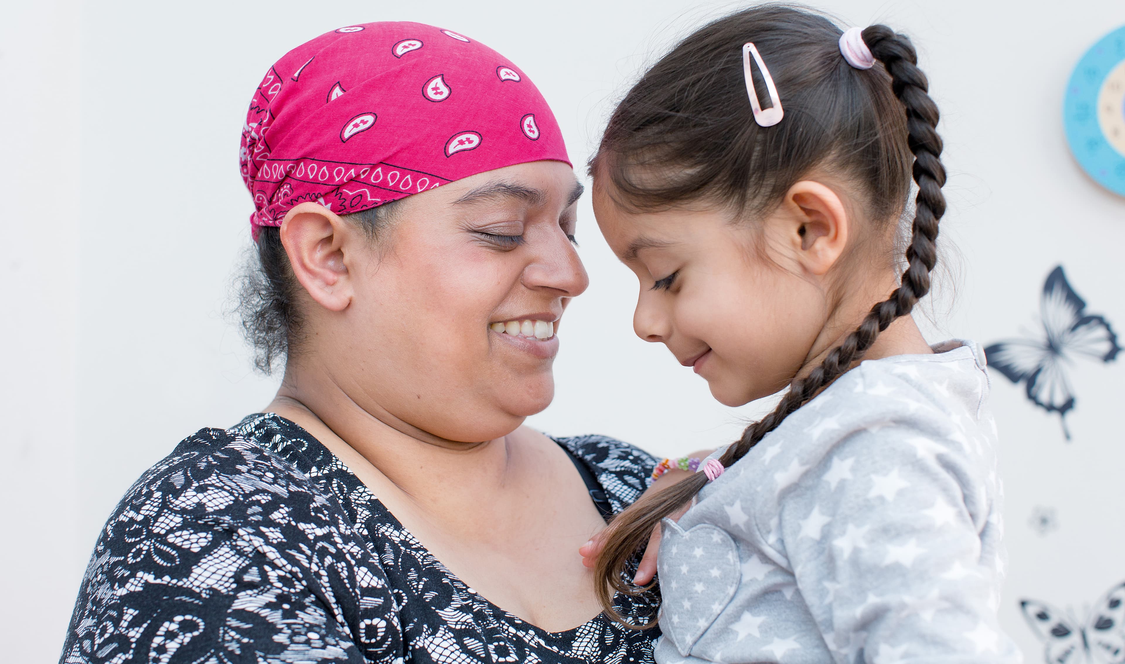 Rajvinder, a lymphoma patient, holding and smiling at her young daughter.