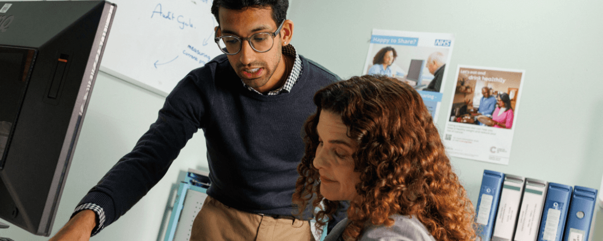 Two NHS doctors reviewing a patient's case file.