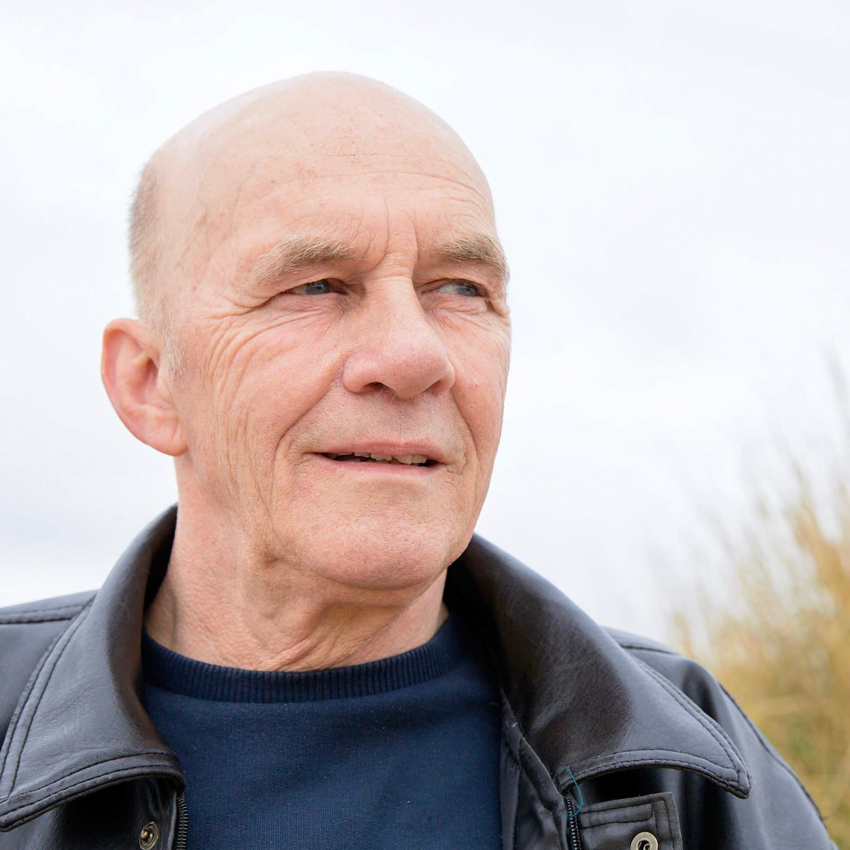 Image of Tommy, standing outside and looking away from the camera.