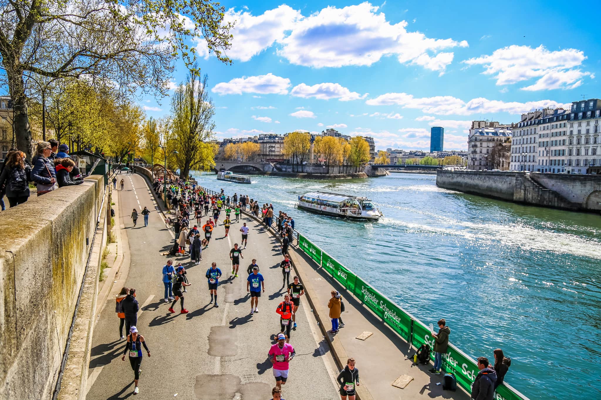 Marathon runners by the side of a river in Paris.