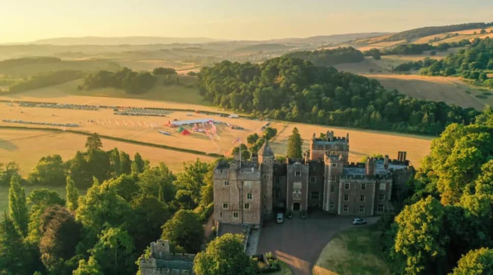 Aerial view of Dunster Castle with event basecamp in the nearby fields.