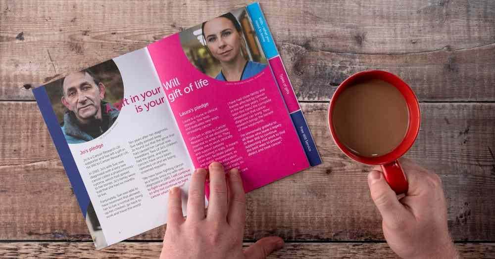 A 'Gift in Will' pack open on a table beside a cup of tea.