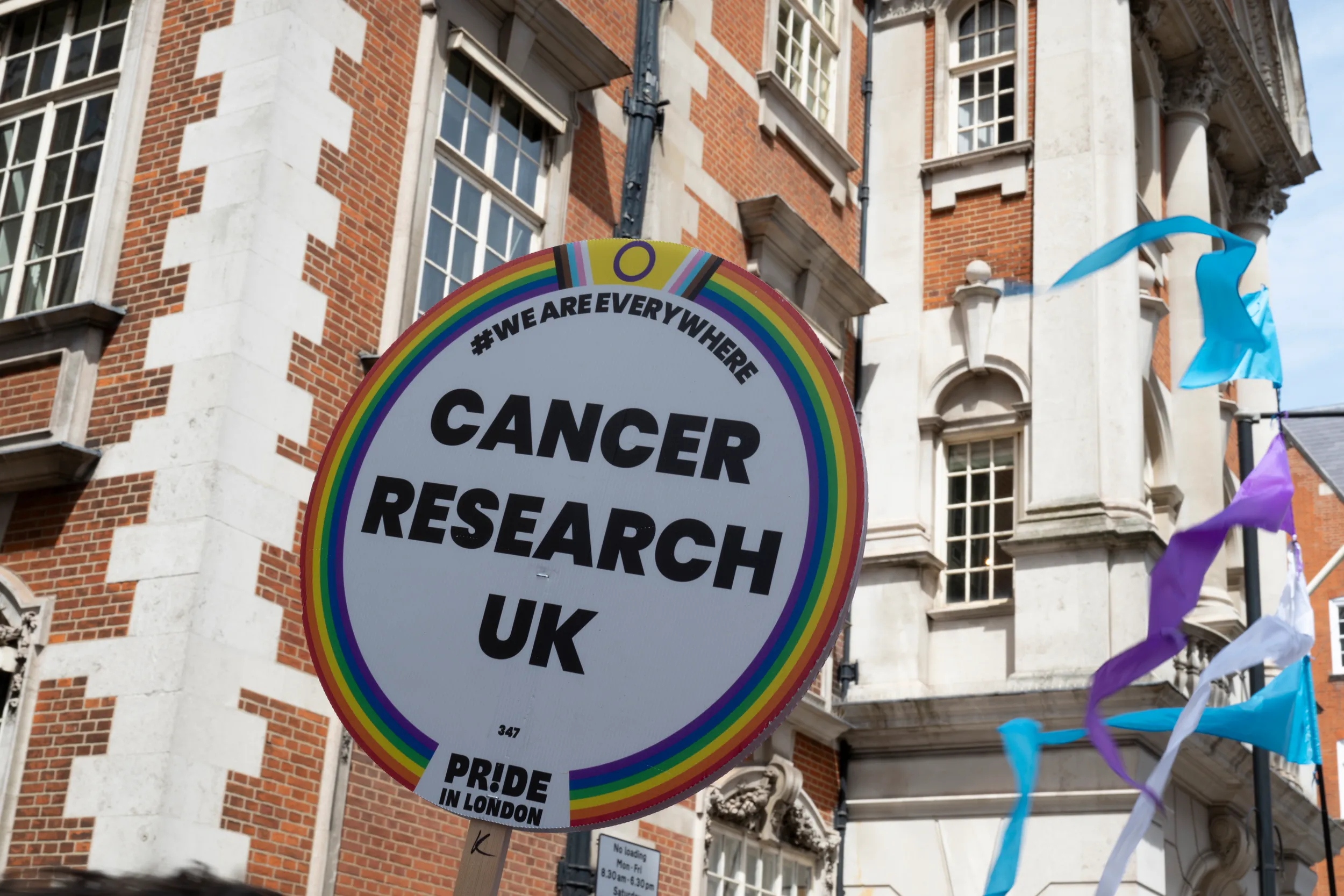 Cancer Research UK Pride banner at a Pride parade.