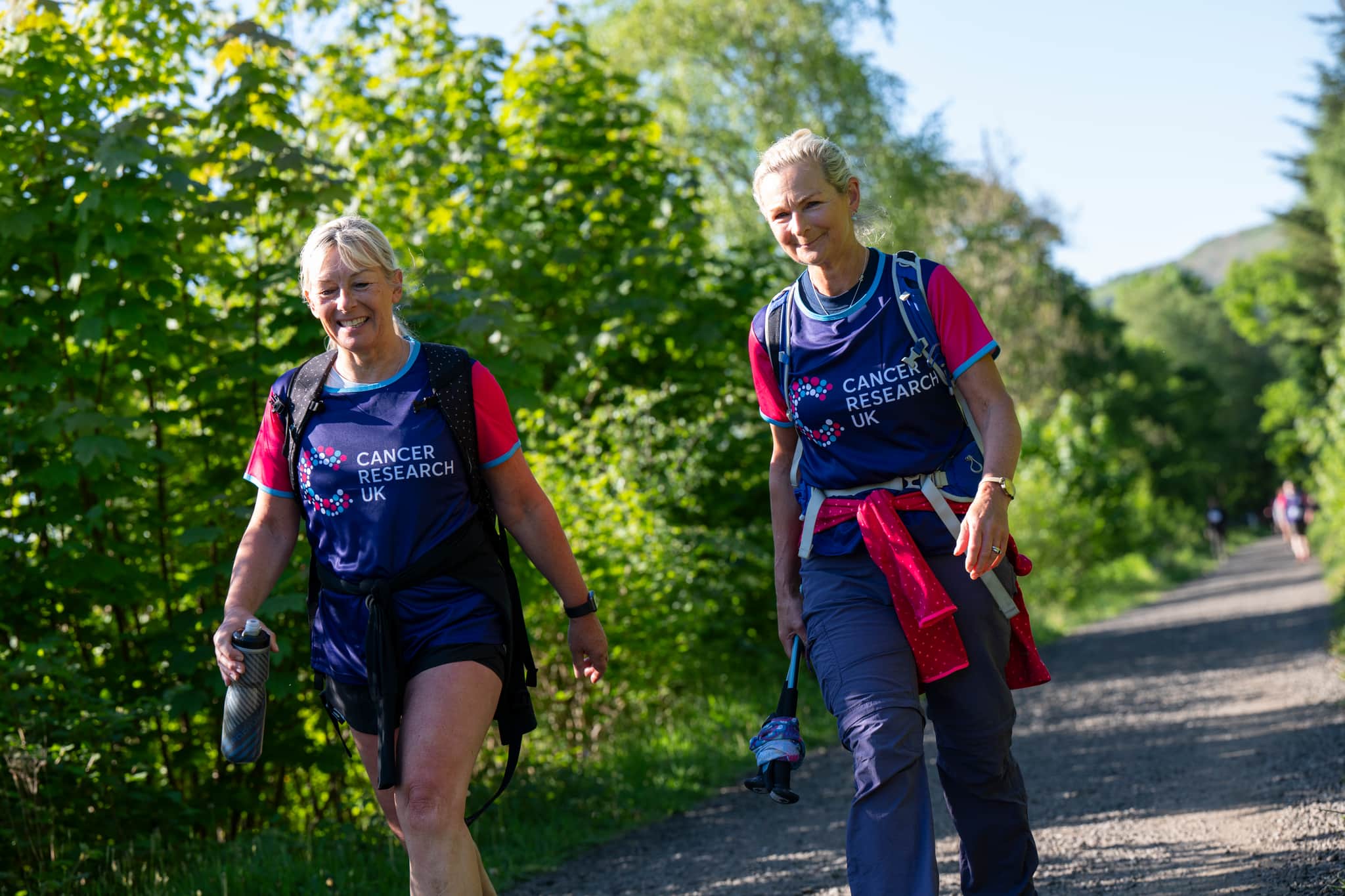 Two hikers walking along a trail.