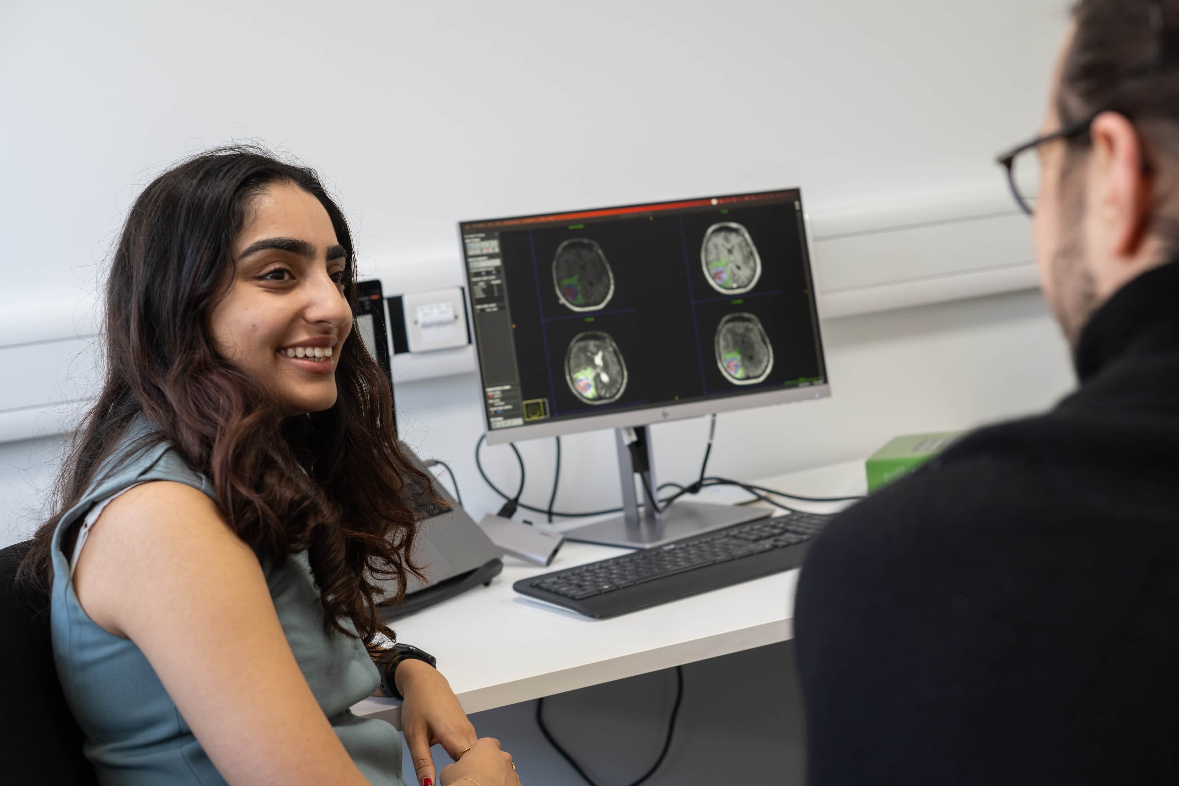 Researchers discussing brain images at a desk.