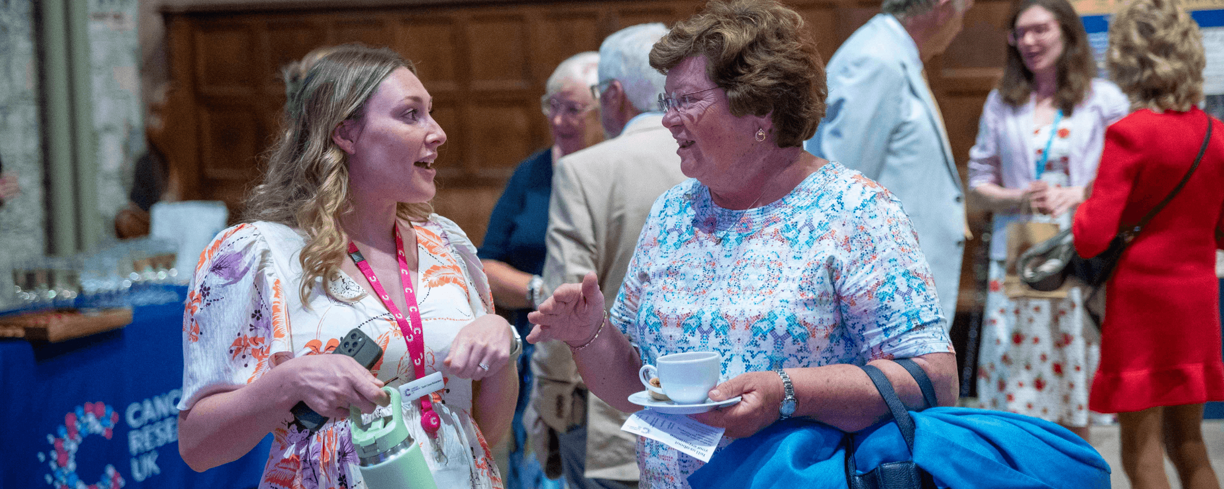 A legacy relationship manager speaking with a supporter at a Legacy event.