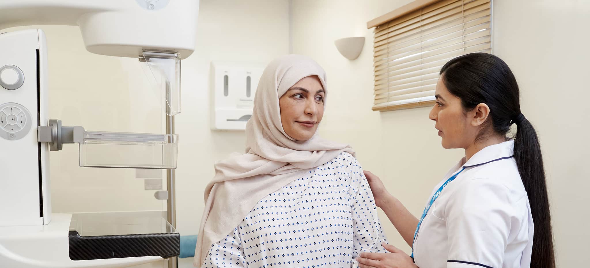 Two people in a medical setting in discussion; one appears to be a patient and the other a healthcare practitioner.